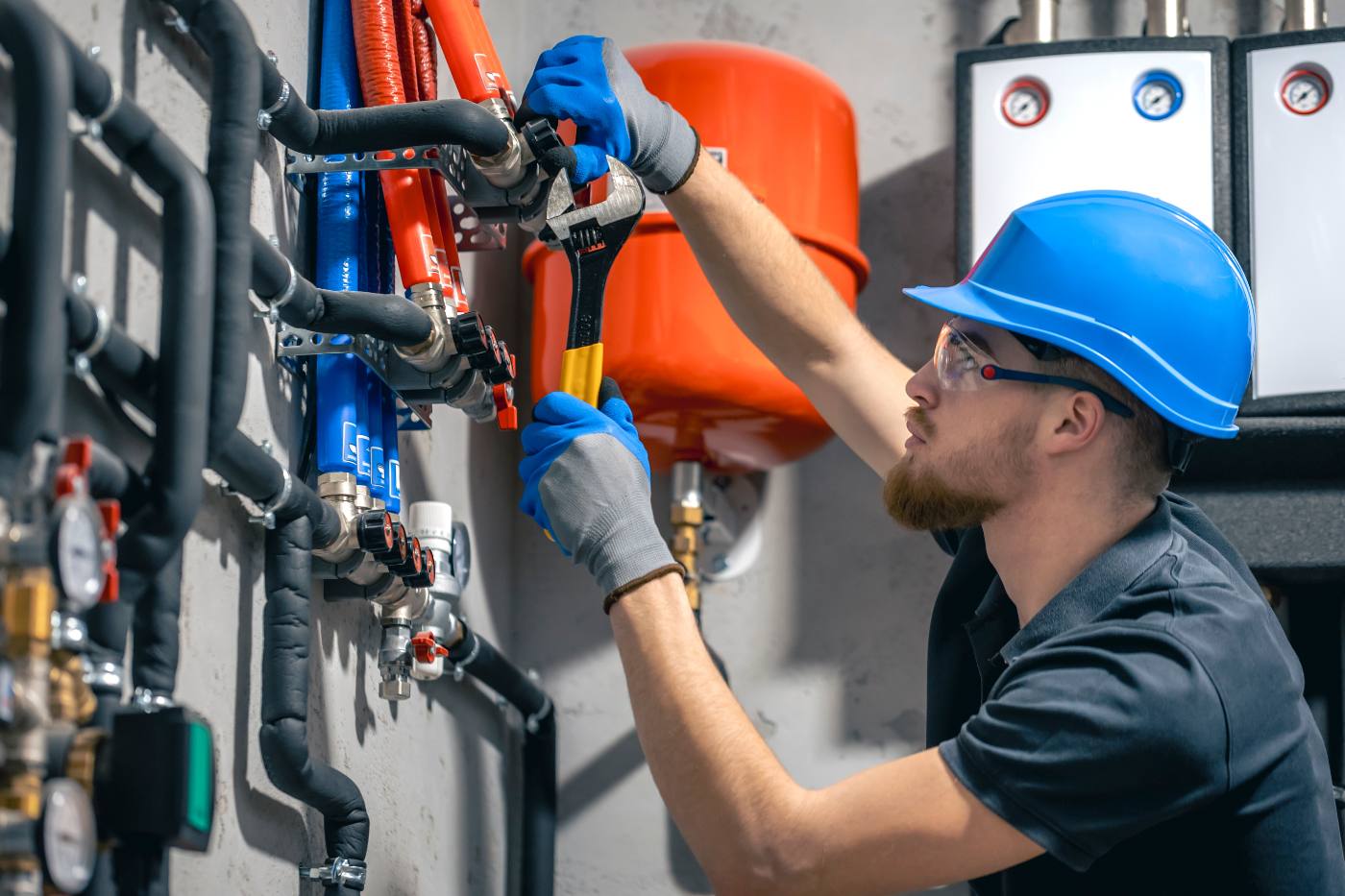 Licensed plumber servicing a water manifold and shutoff valves in a Murrieta home